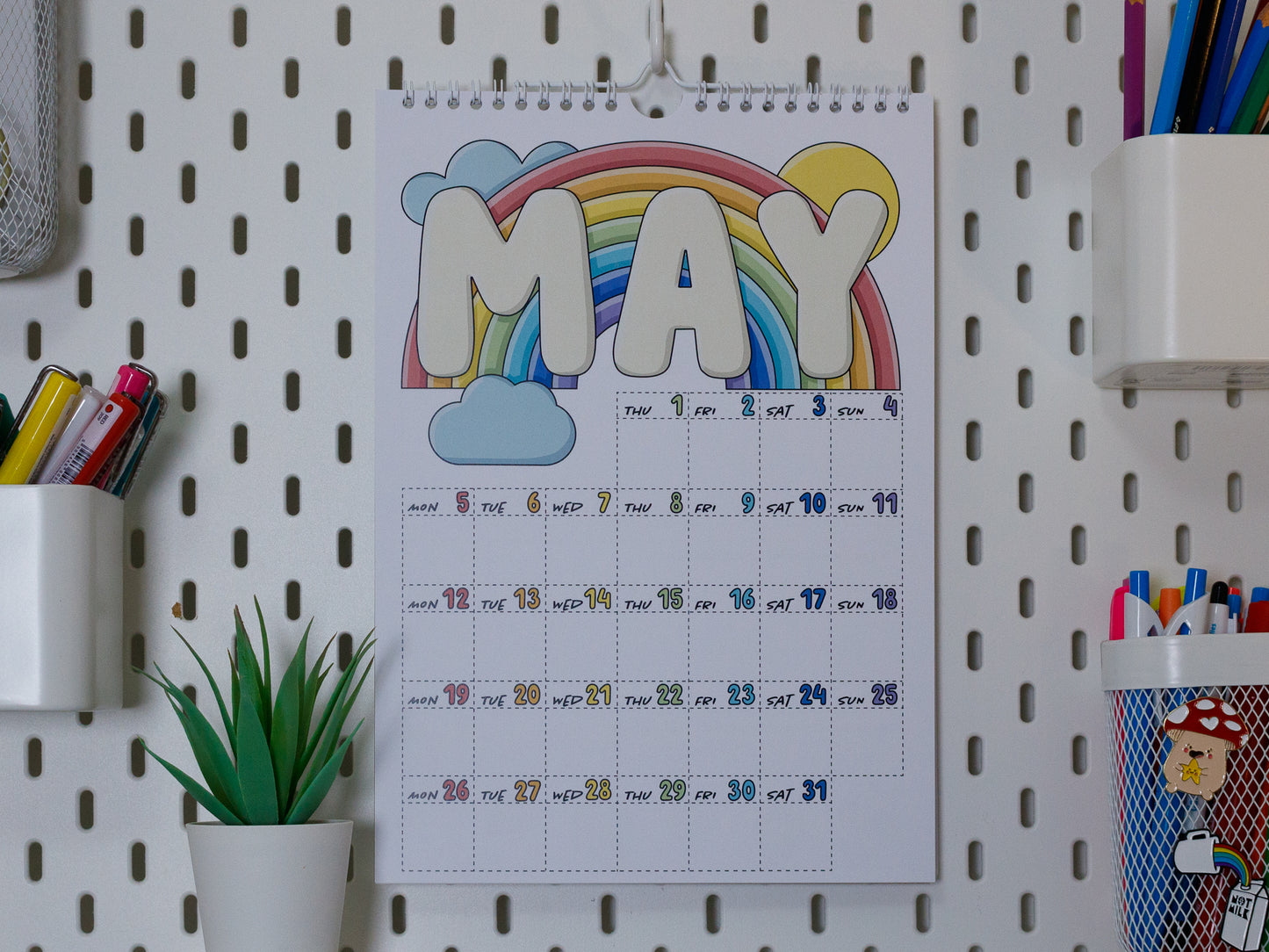 2025 Colourful Wall Calendar hanging on office peg board - May with Rainbow Design