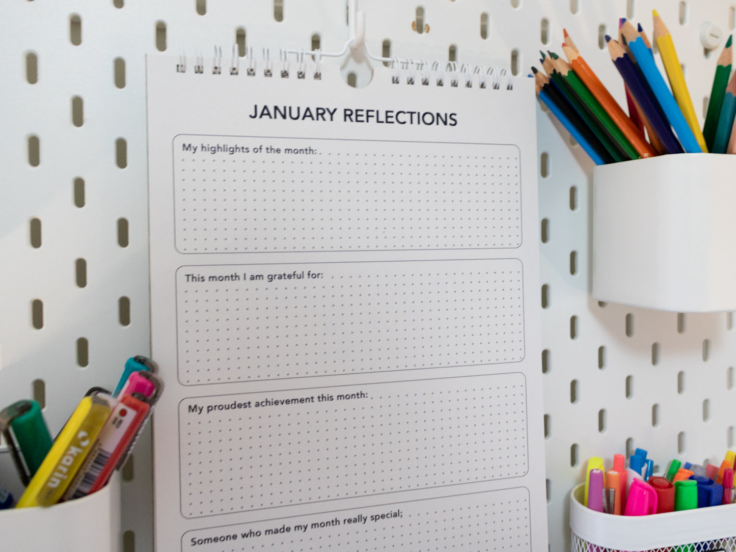 2026 Colouring Calendar on a pegboard with markers and crayons - January reflection page