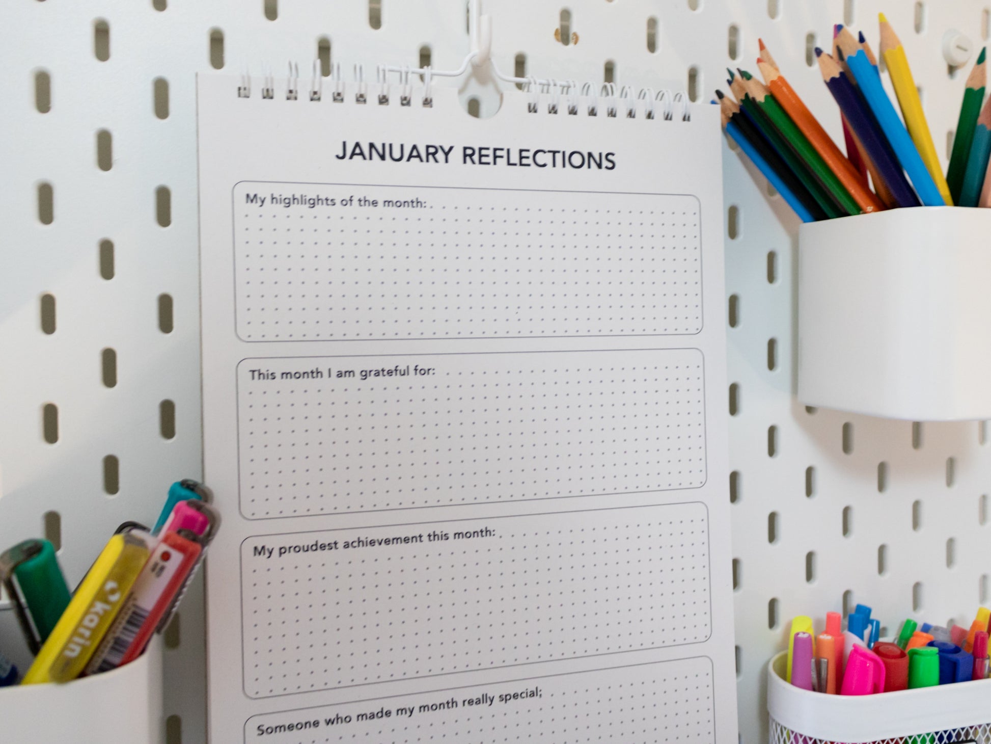 2026 Colouring Calendar on a pegboard with markers and crayons - January reflection page