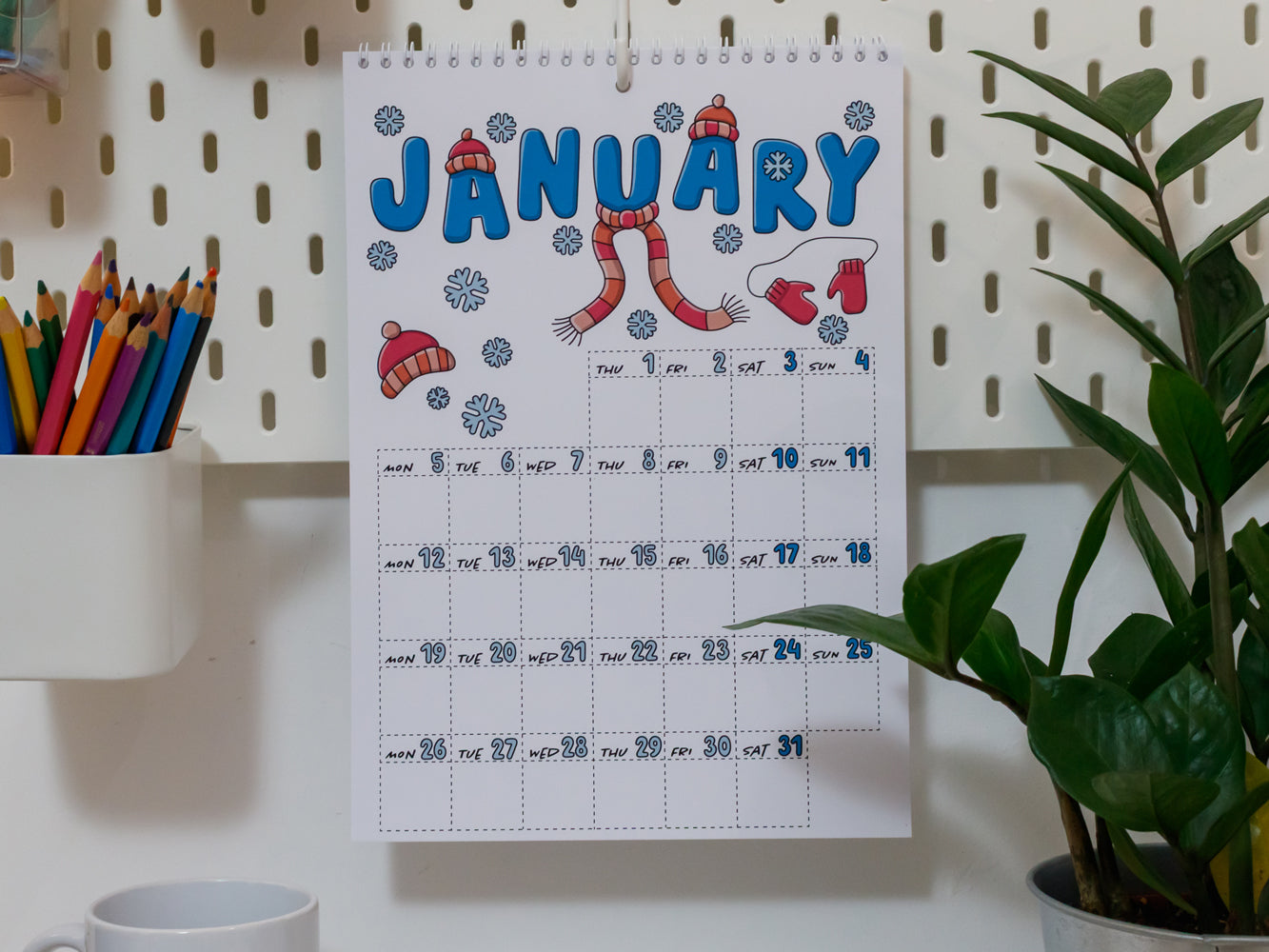 2026 Wall Calendar: January page with winter-themed design on a pegboard wall.