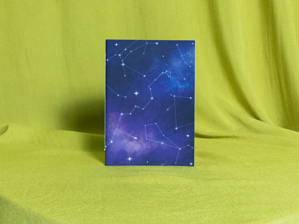 Small sketchbook with star constellation design on a green fabric background