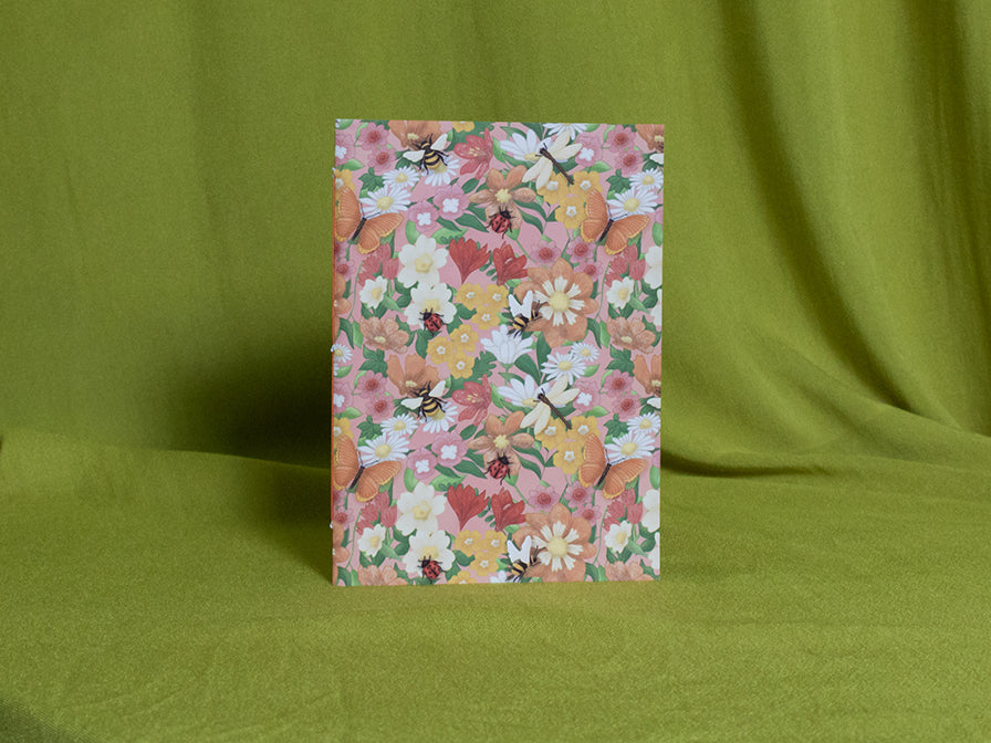 Small floral patterned sketchbook on a green fabric background