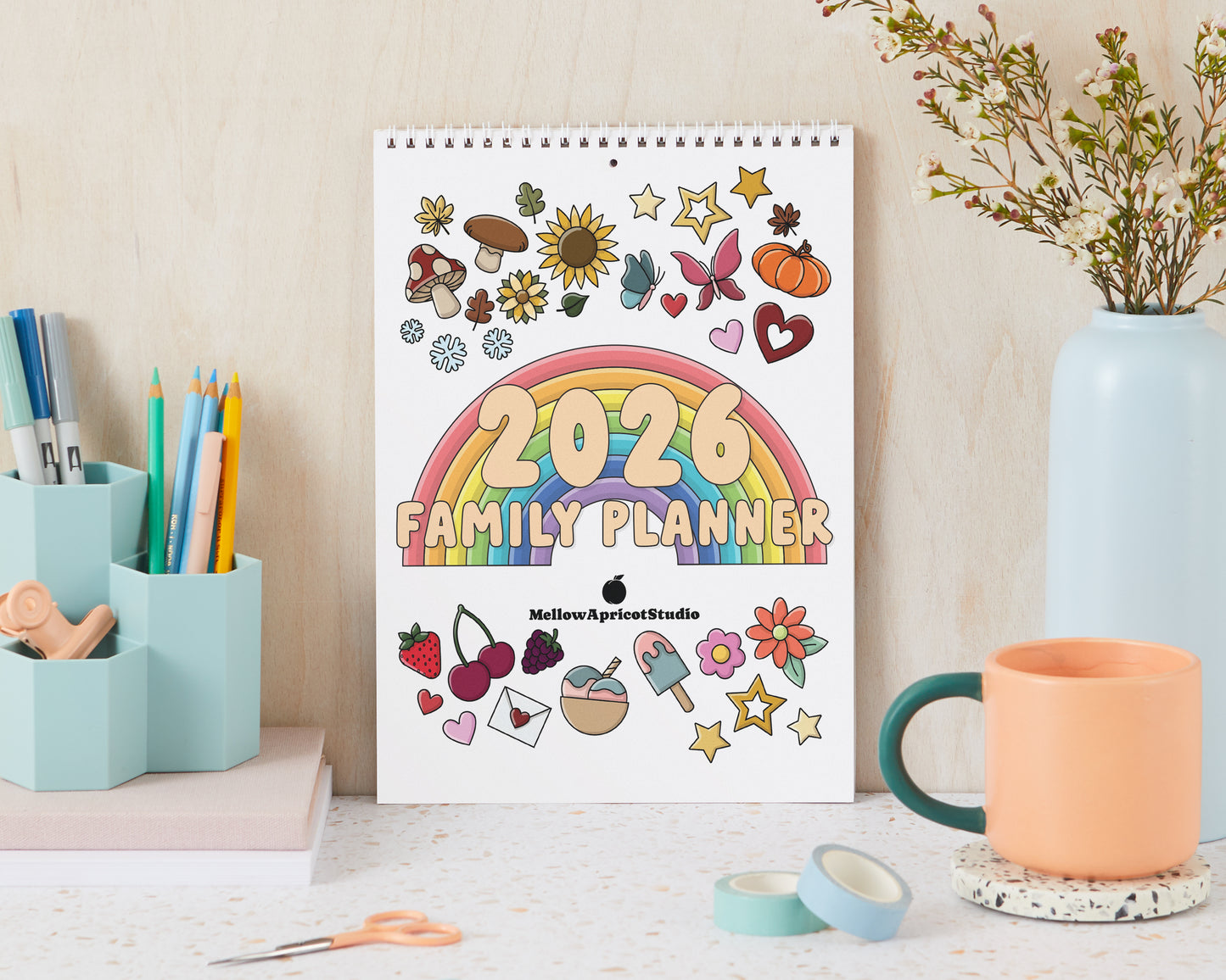 2026 Family Planner with colorful design on a desk with stationery items.
