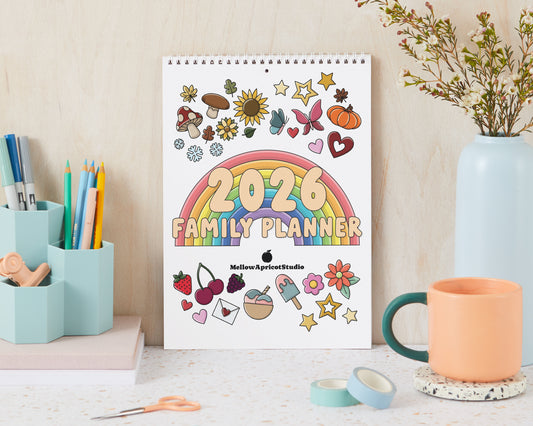 2026 Family Planner with colorful design on a desk with stationery items.