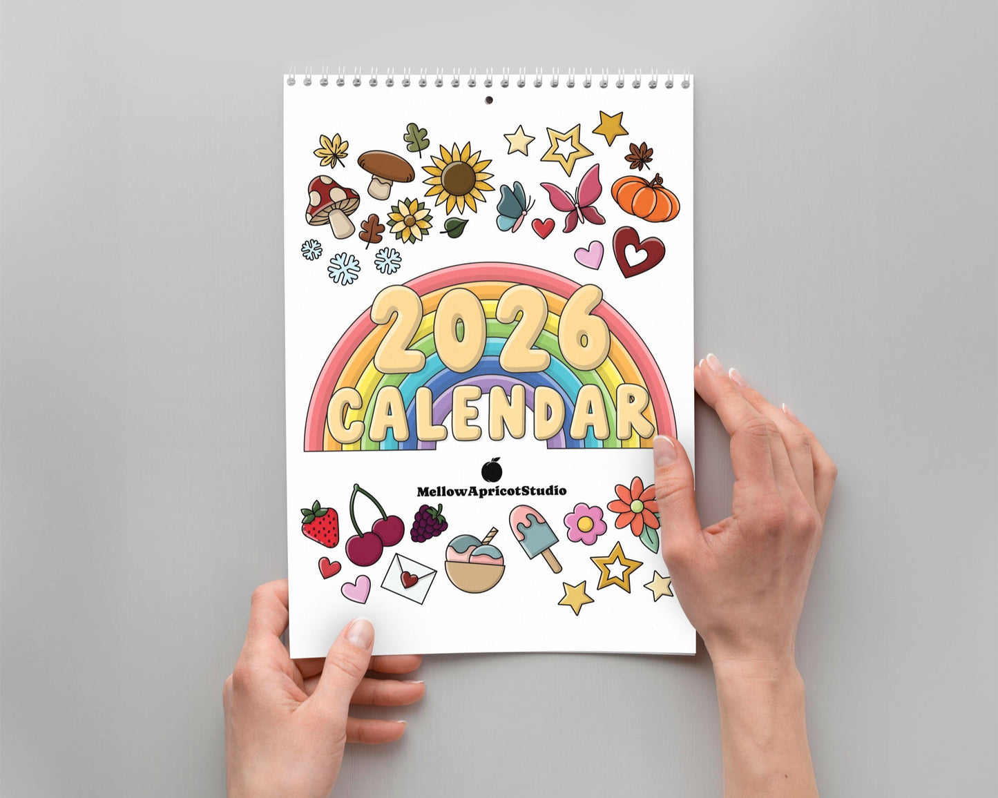 2026 calendar with colorful design held by hands on a gray background