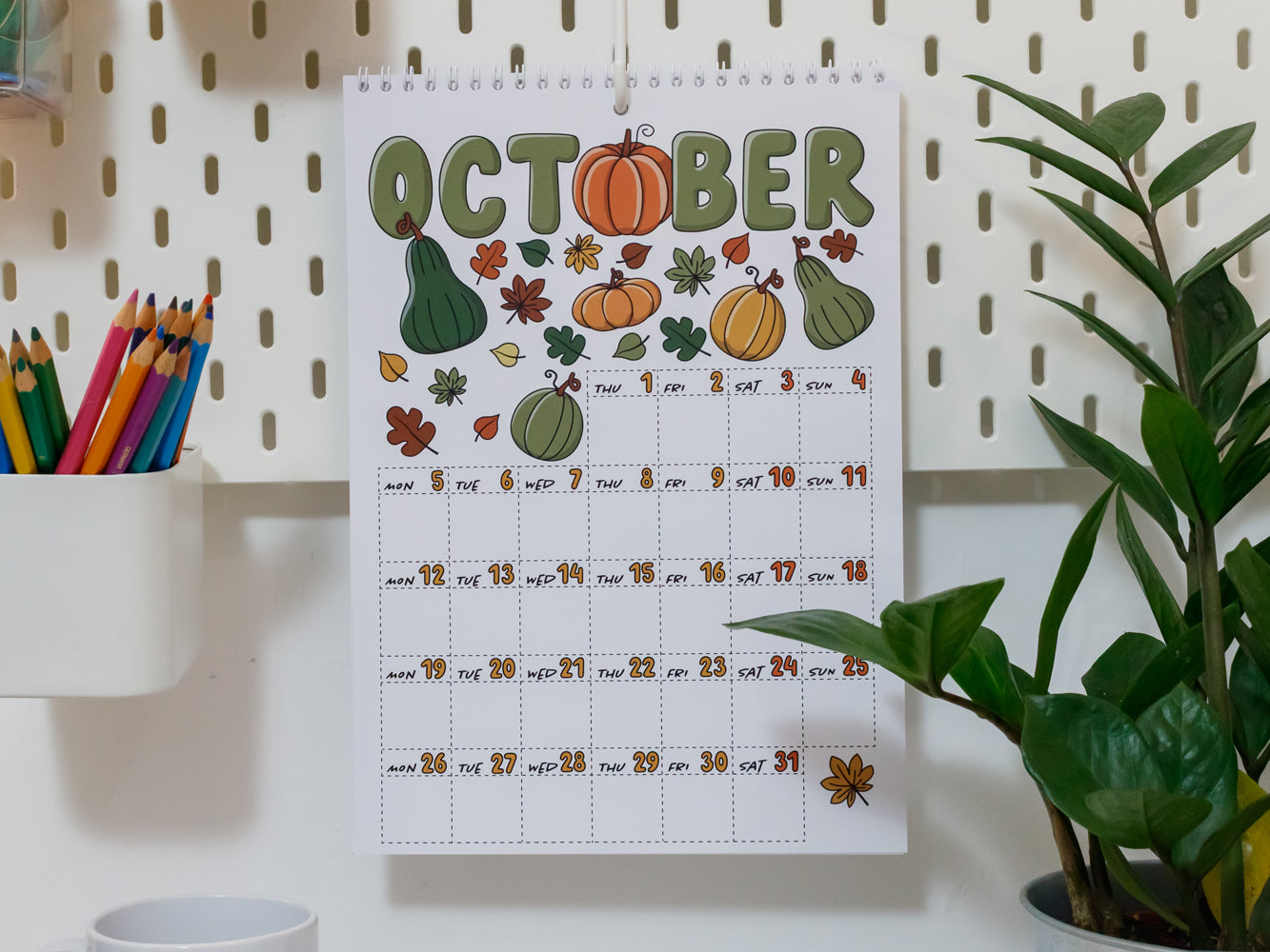 2026 Wall Calendar: October page with autumn illustrations on a white wall.
