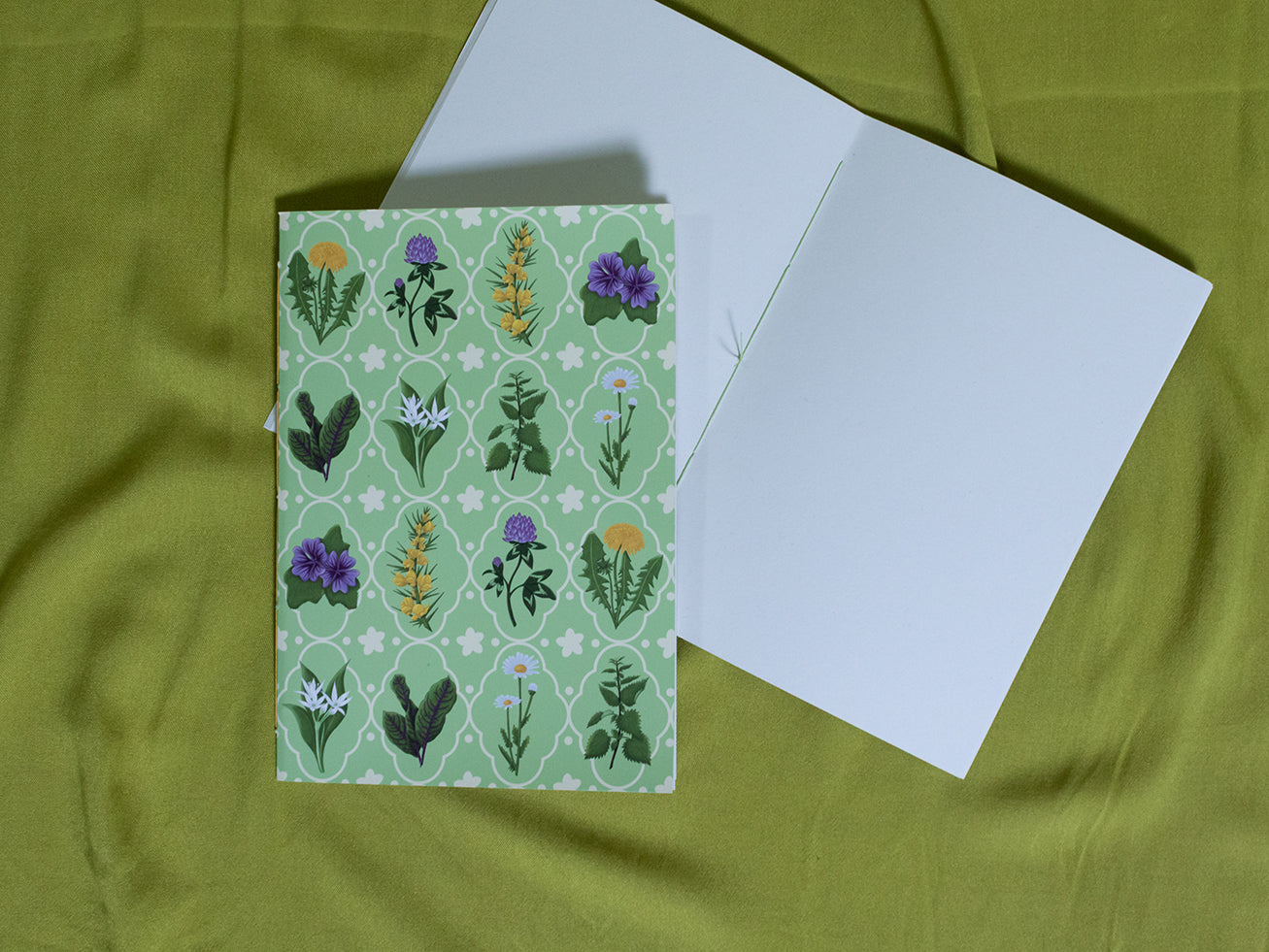 Sketchbook with floral pattern on green fabric