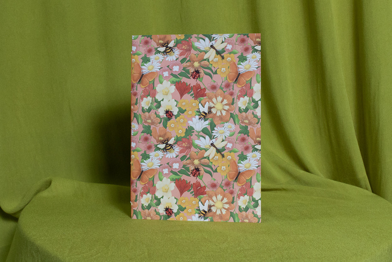 Floral sketchbook with a colourful pattern on a green fabric background