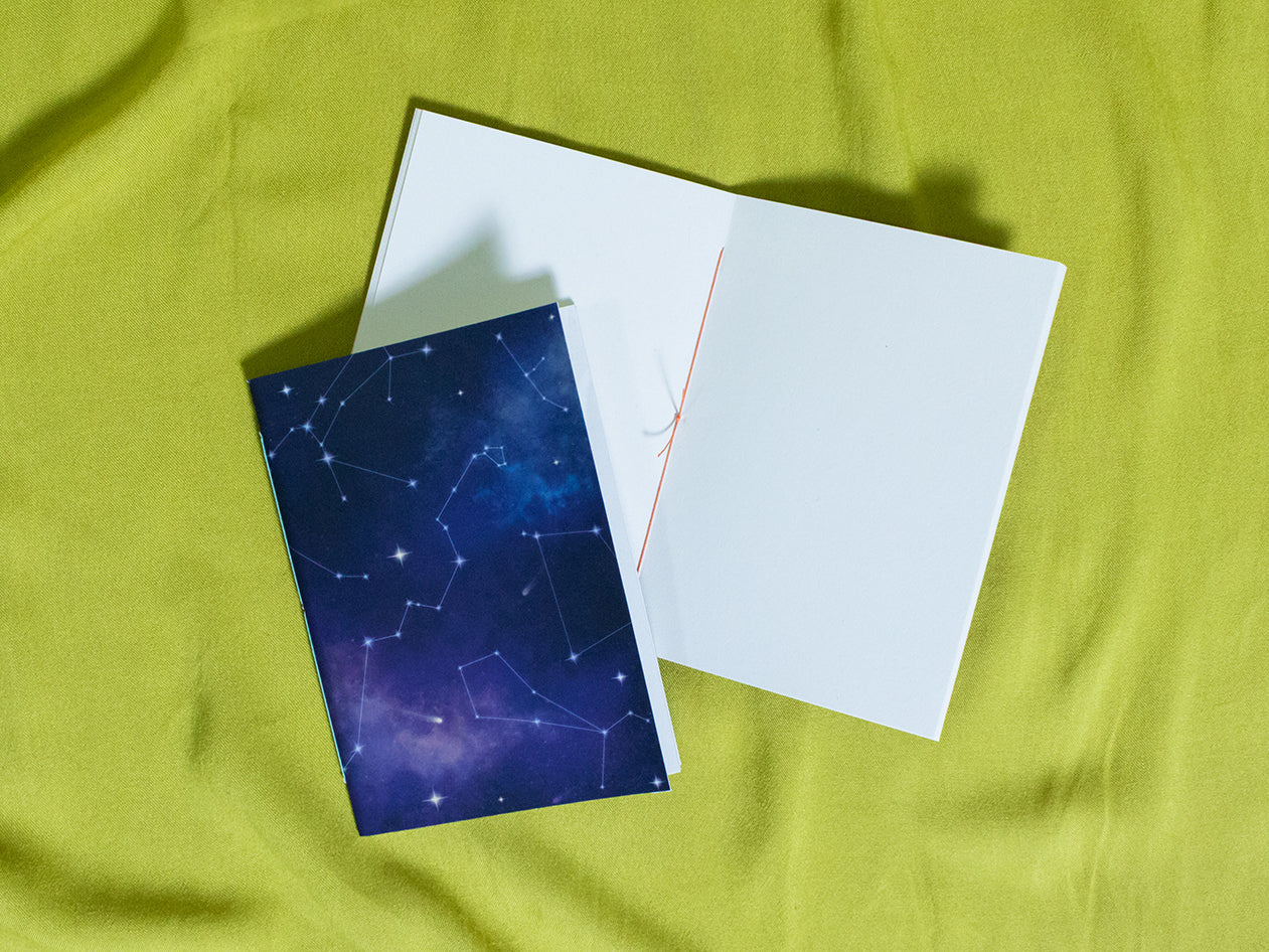 Small sketchbook with star constellations design on a green fabric background