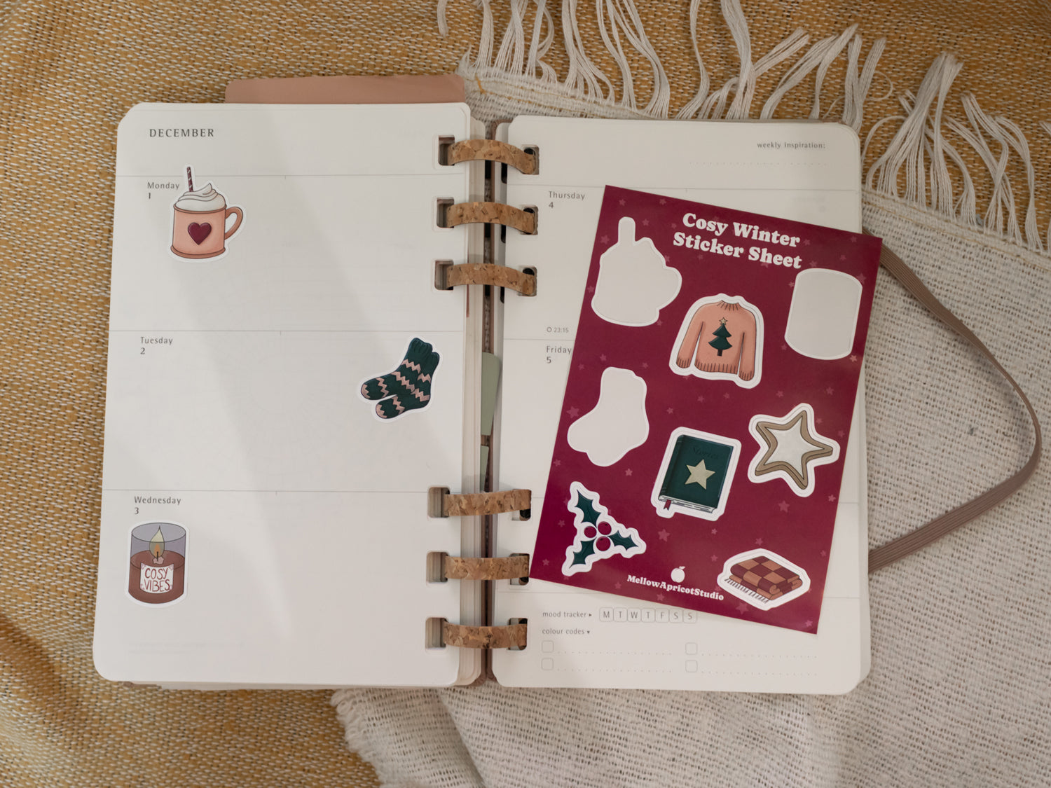 Open planner with cosy winter stickers on a textured surface