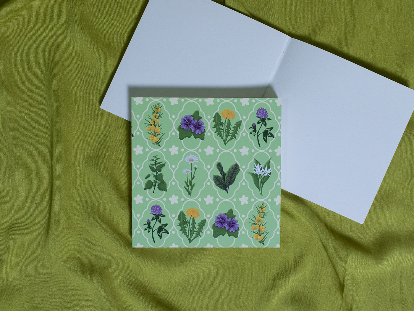 Square sketchbook with floral pattern on green fabric