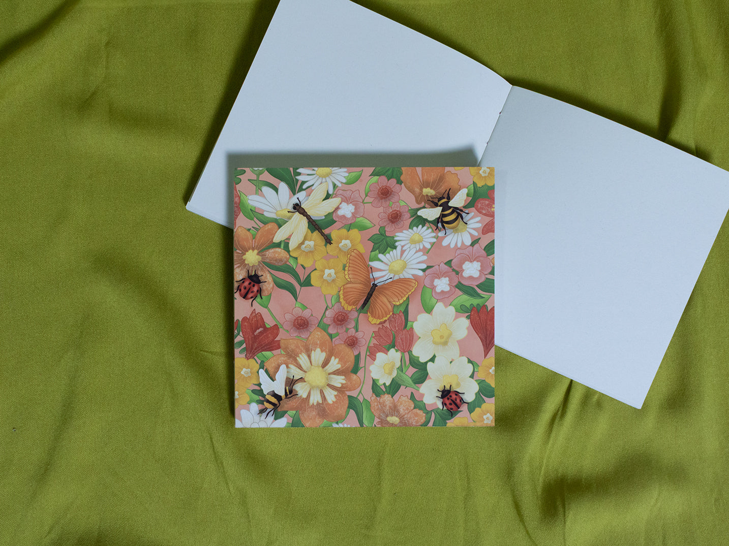Floral square sketchbook with butterflies on a green fabric background